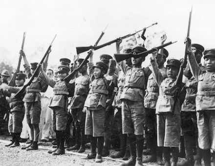 Japanese children in uniforms raise their arms to salute emperor Hirohito, c. 1932. Narodowe Archiwum Cyfrowe. Public Domain.