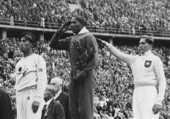 Jesse Owens, Luz Long, and Naoto Tajima recieve medals for long jump at the Berlin Olympics, 1 August 1936. Narodowe Archiwum Cyfrowe. Public Domain.