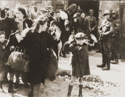 Jews captured during the suppression of the Warsaw Ghetto Uprising are forced from their shelters and marched to the Umschlagplatz for deportation, 1943. United States Holocaust Memorial Museum, courtesy of National Archives and Records Administration, College Park. Public Domain.
